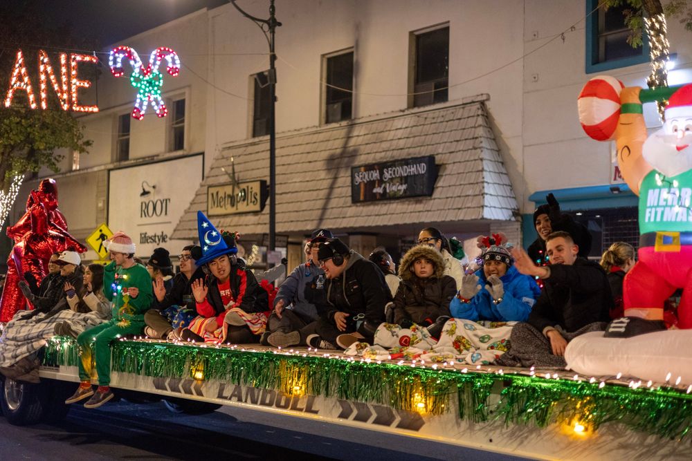 Athletes wave from a decorated float at a downtown Visalia holiday parade